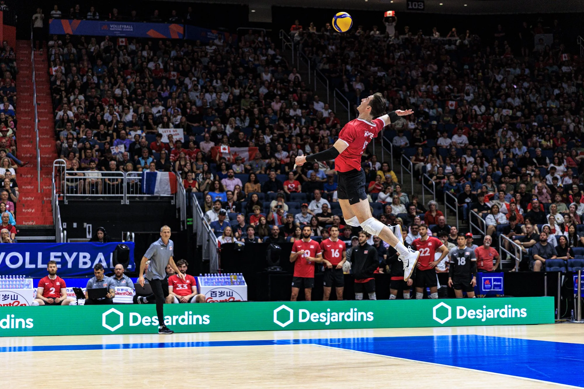 Joueur de volleyball au service lors du passage de la VNL au Centre Vidéotron à Québec, Canada