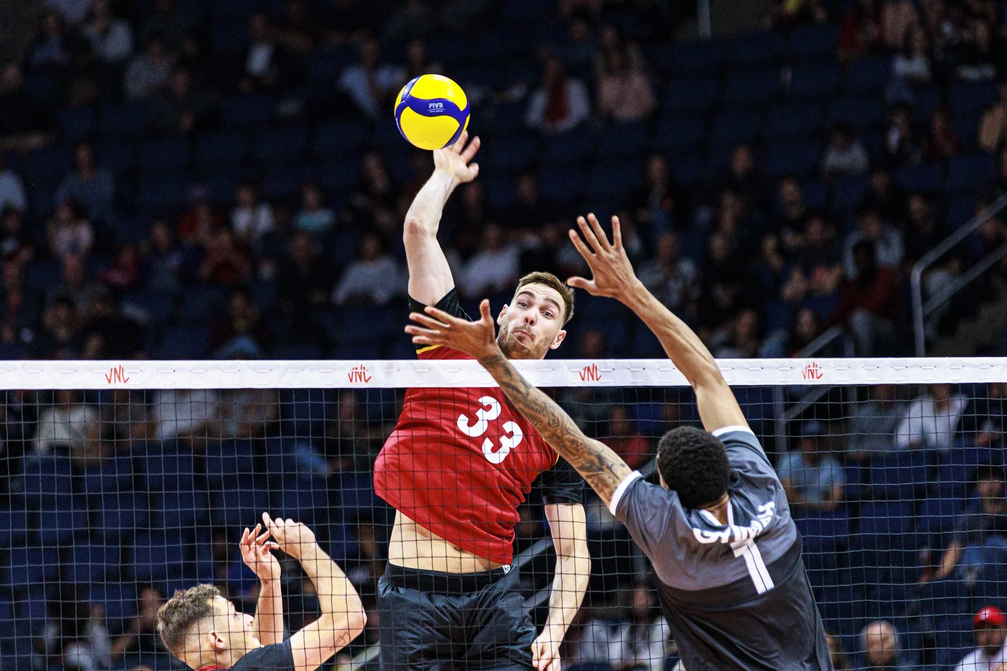 Joueur de volleyball en attaque au filet lors du passage de la VNL au Centre Vidéotron à Québec, Canada