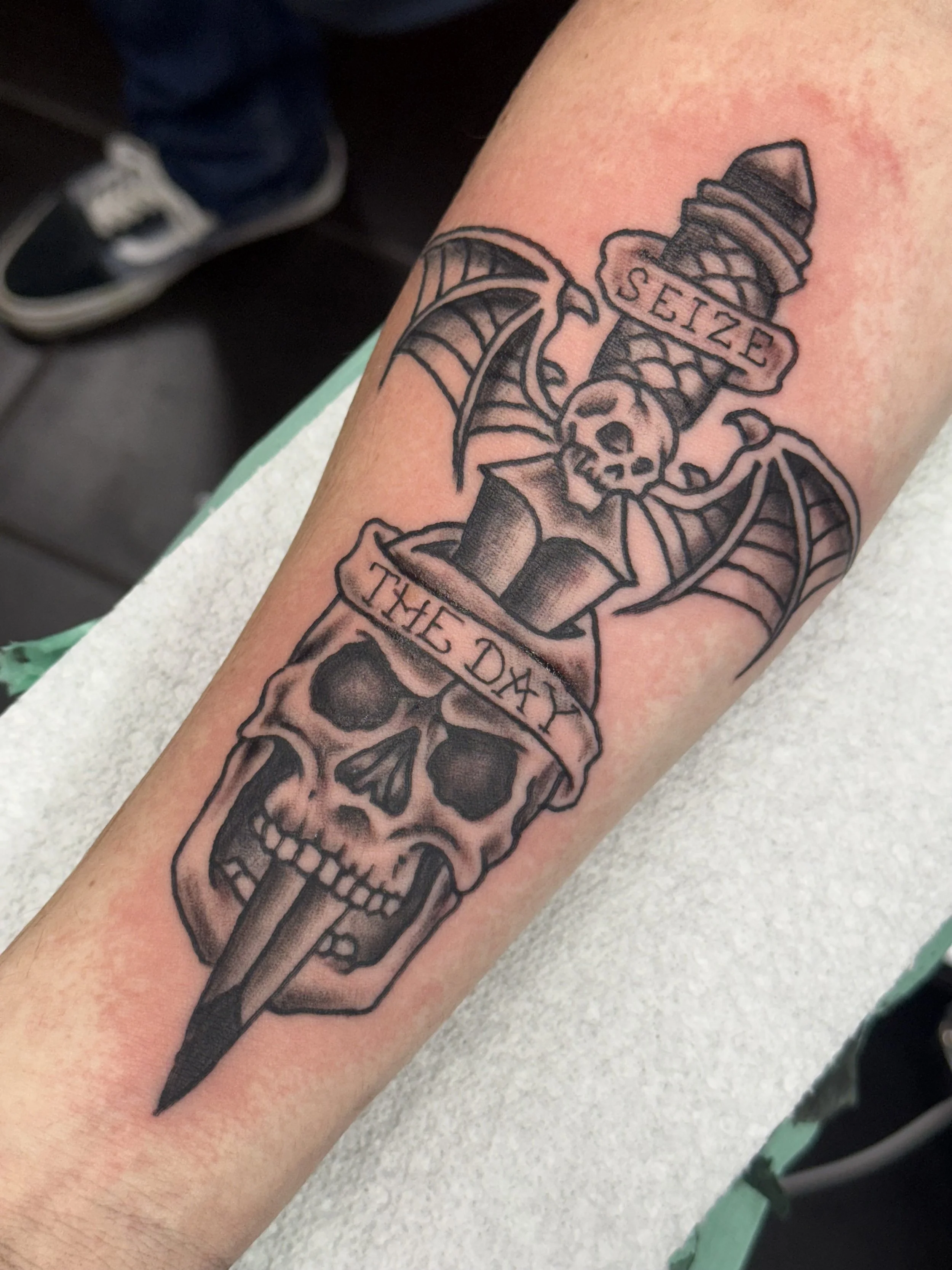 black-grey-skull-dagger-forearm-tattoo-treasure-island-fl.jpeg