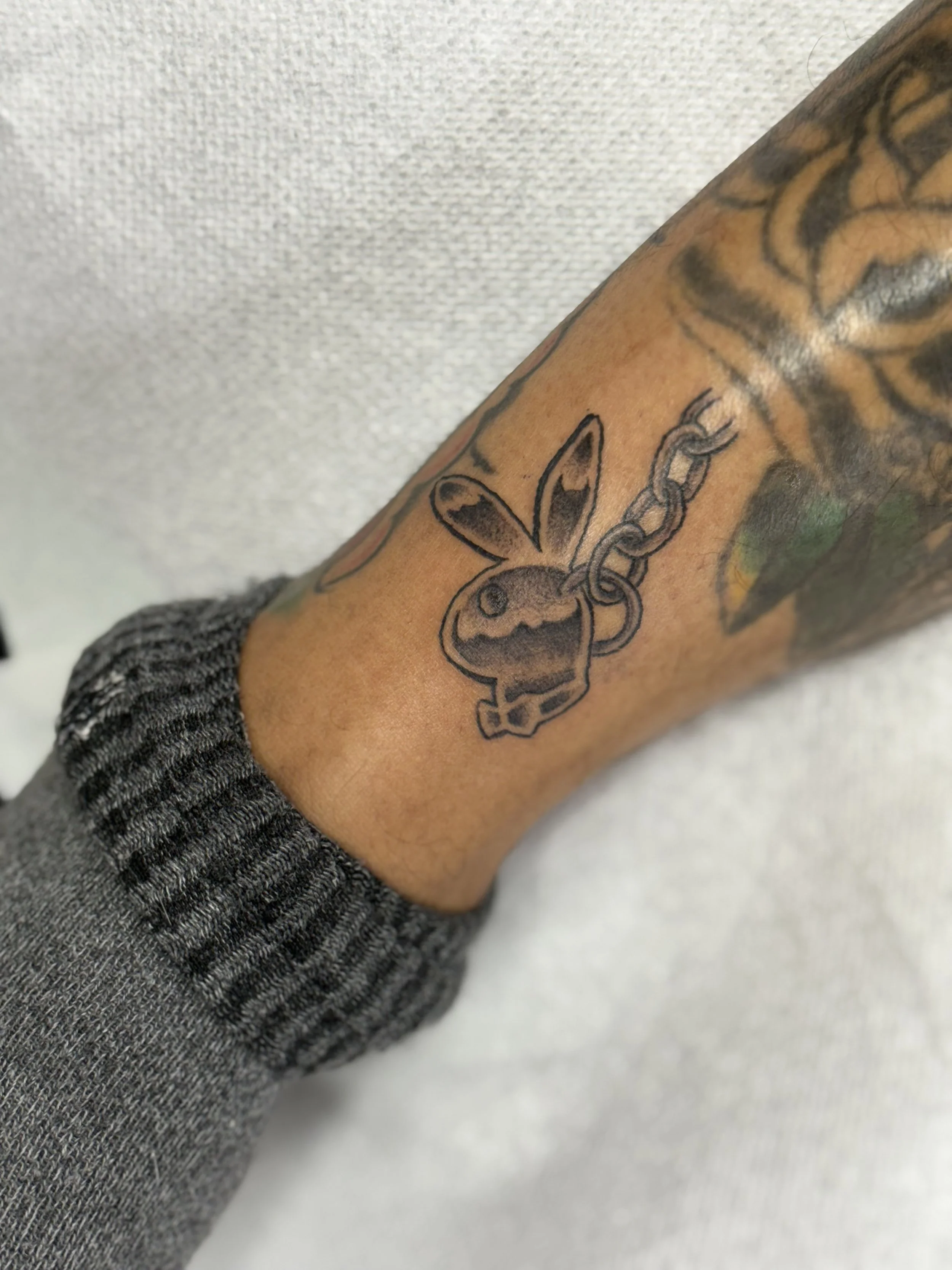black-grey-playboy-bunny-leg-tattoo-treasure-island-fl.jpeg