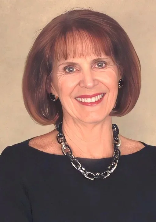 Elderly woman with red hair and purple necklace standing by a fence, smiling.