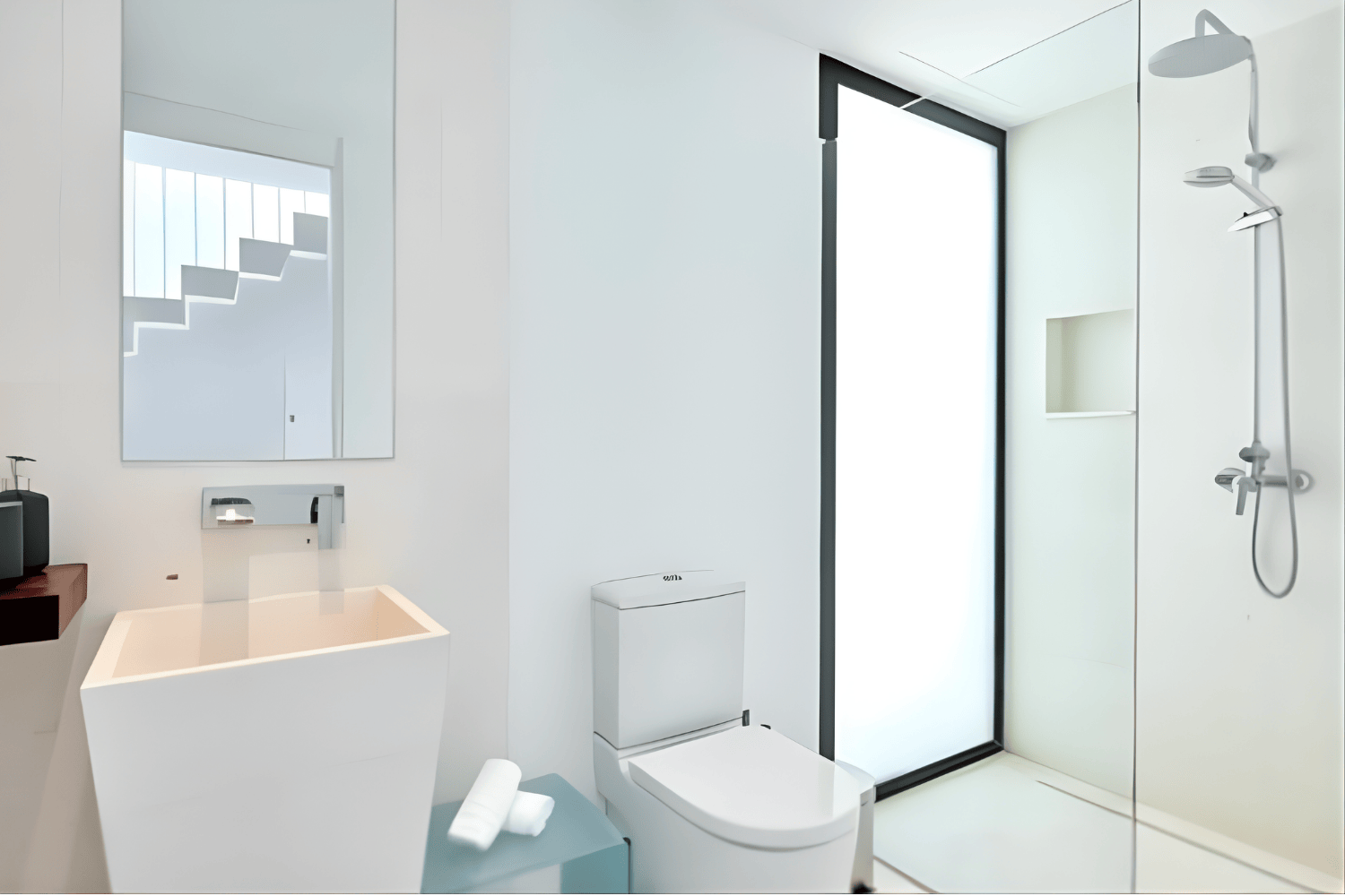 Minimalist white bathroom with a shower, toilet, small sink, and a large mirror.
