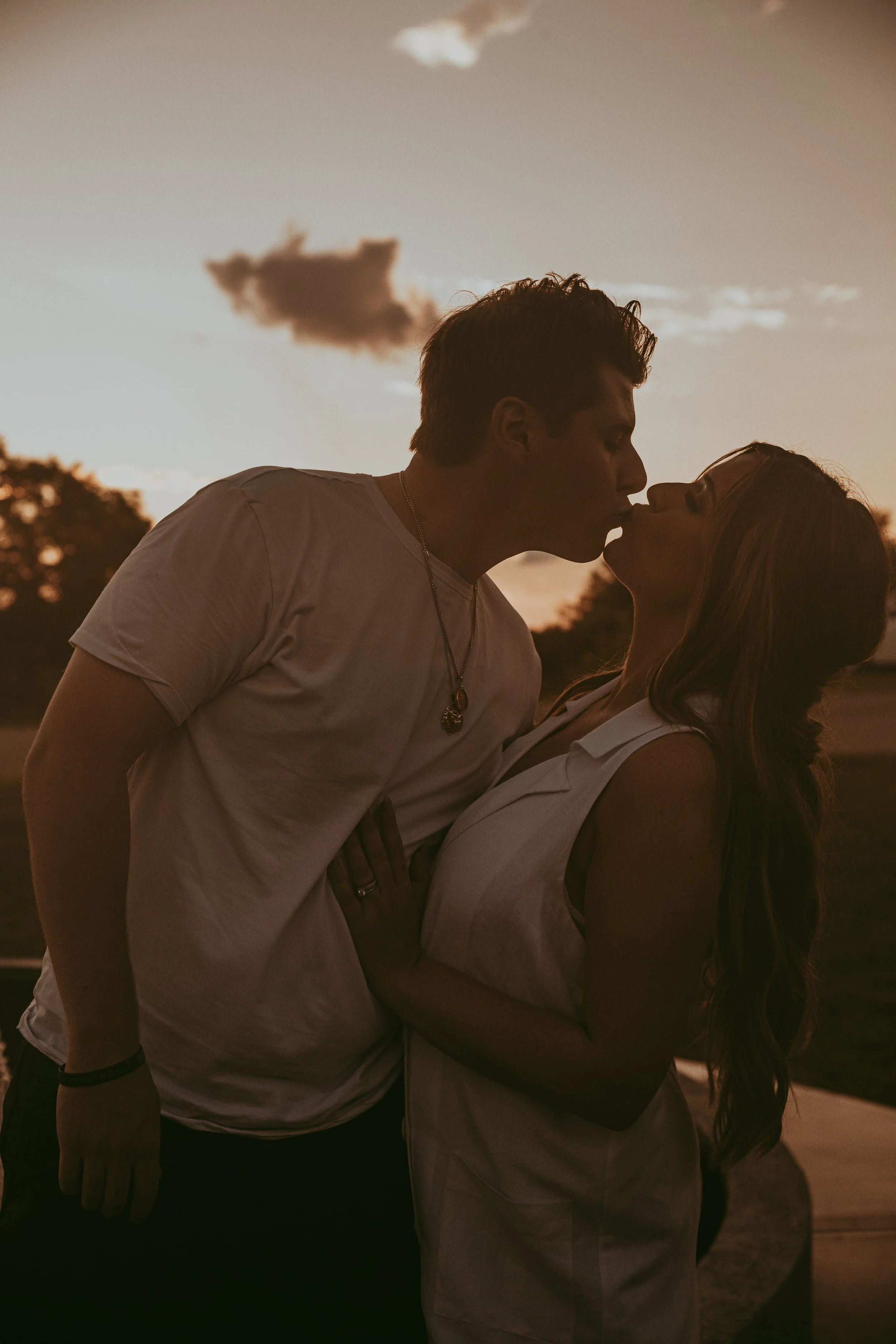 A couple sharing a kiss during sunset