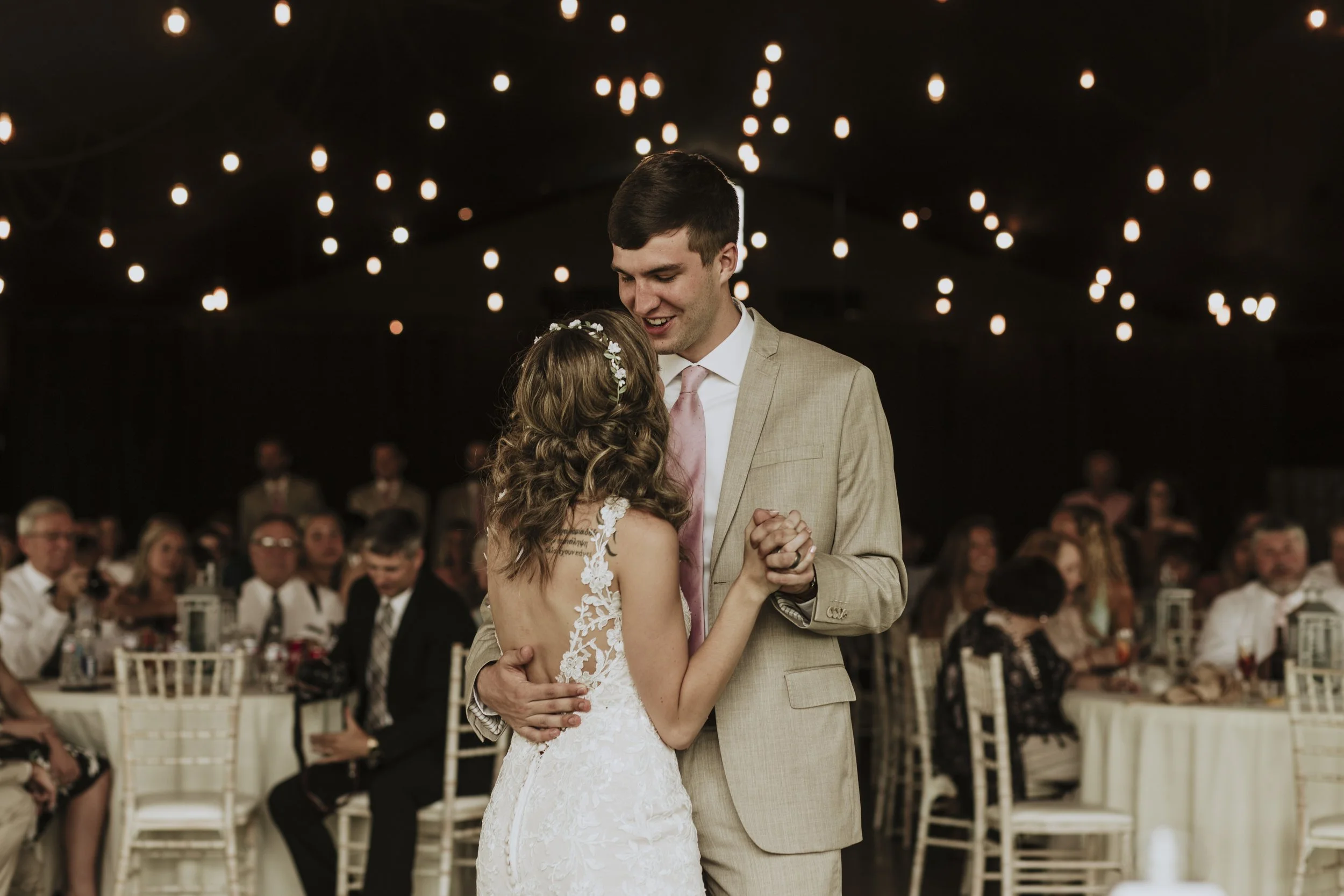 As the bride and groom lovingly embrace, their eyes locked and smiles radiant, the world around them seems to fade away, leaving only their profound connection. The photograph captures this intimate moment, immortalizing the pure joy and devotion sha