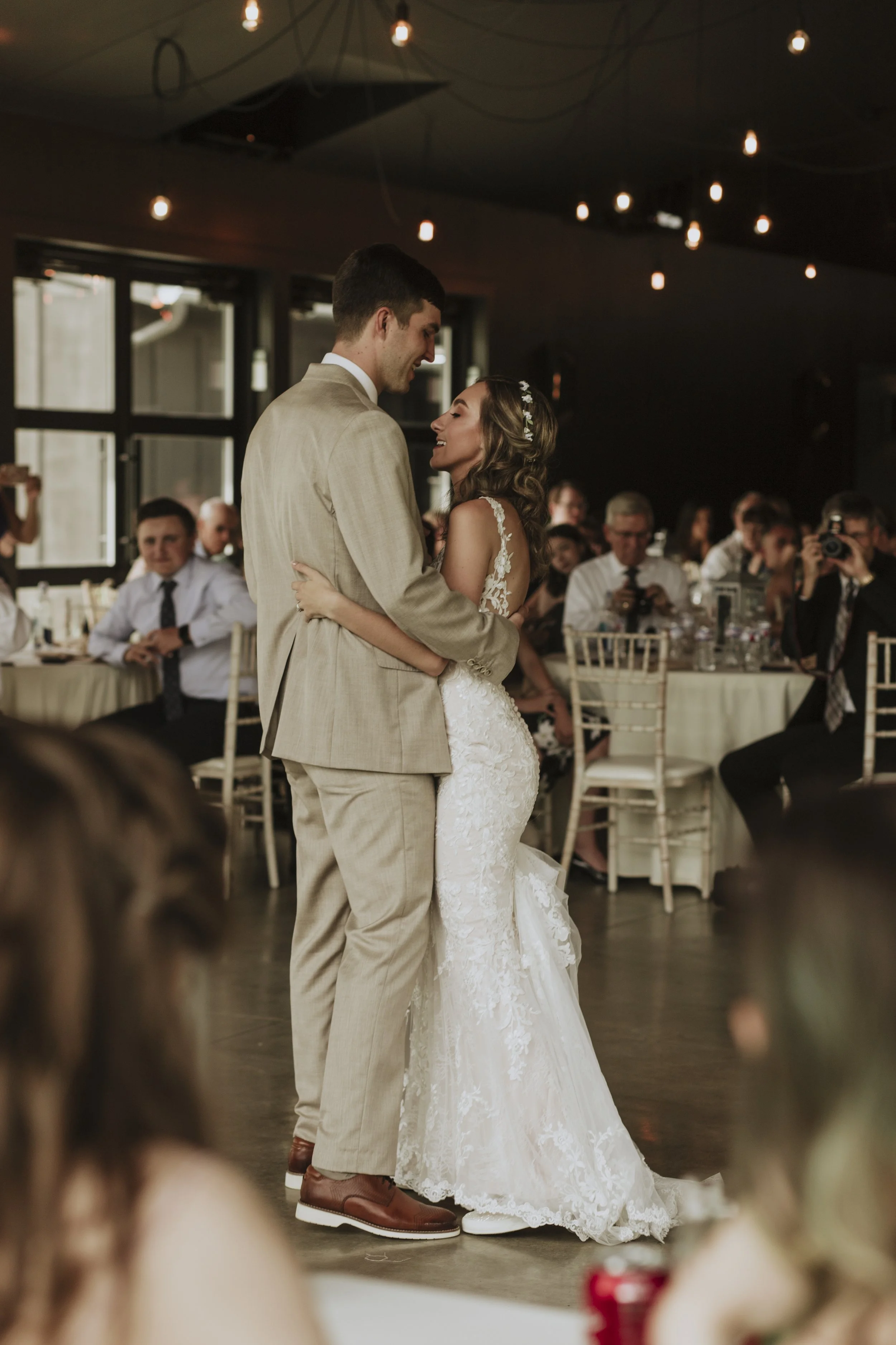As the bride and groom lovingly embrace, their eyes locked and smiles radiant, the world around them seems to fade away, leaving only their profound connection. The photograph captures this intimate moment, immortalizing the pure joy and devotion sha
