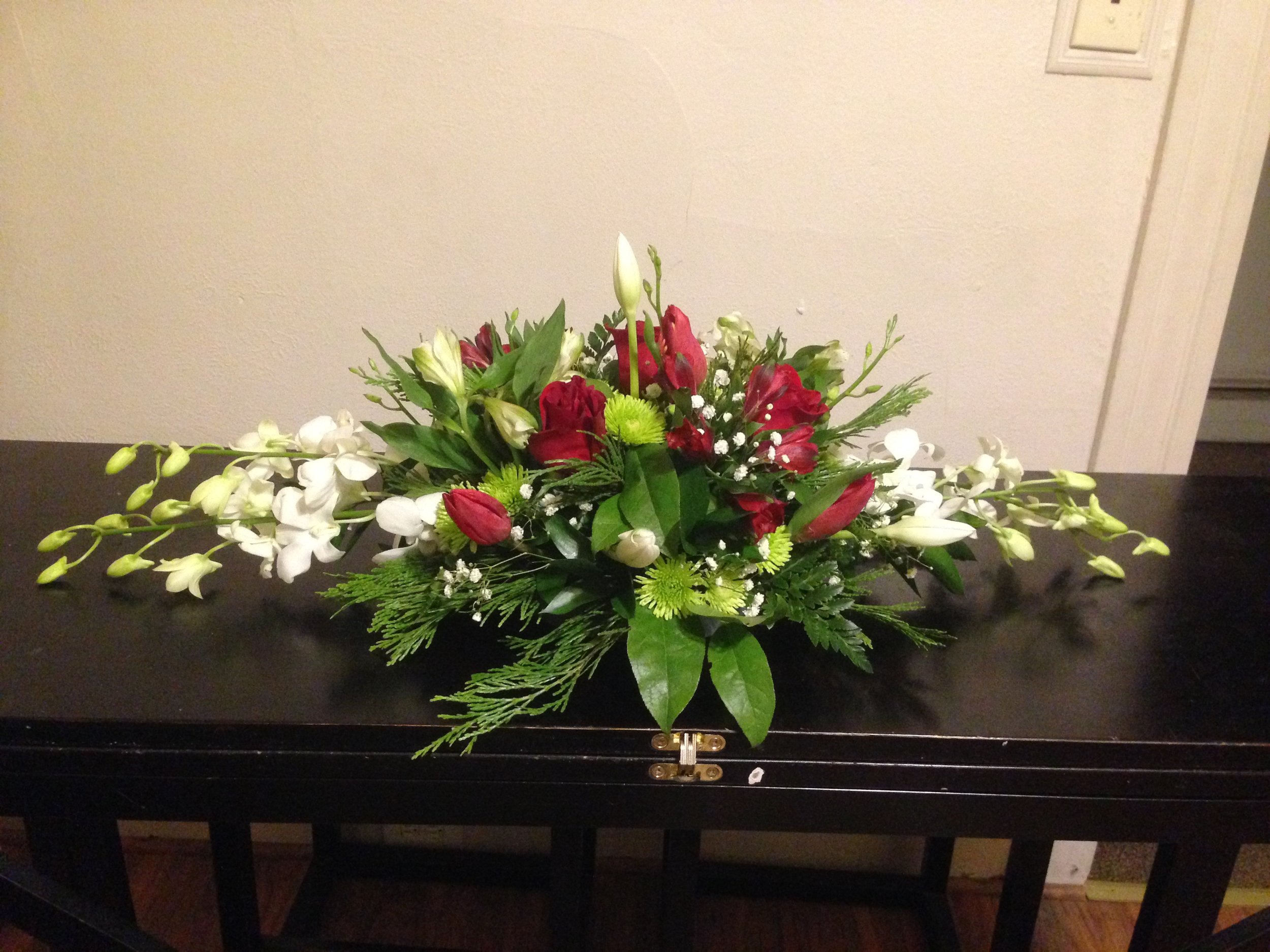 A Christmas centerpiece created with classic reds, greens, and whites.
