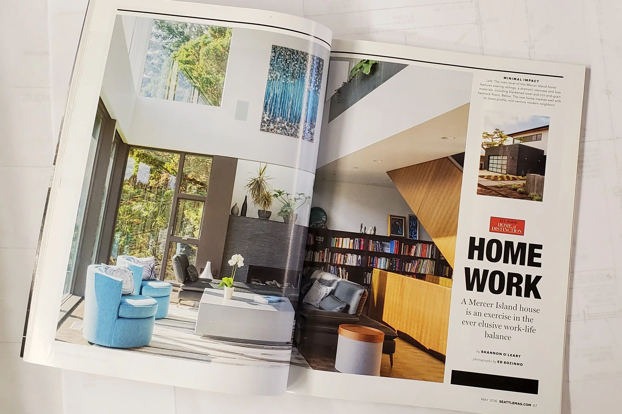 Magazine spread featuring a modern home interior with large windows, blue chairs, a fireplace, bookshelves, and an article titled "HOME WORK: A Mercer Island house is an exercise in the ever elusive work-life balance."
