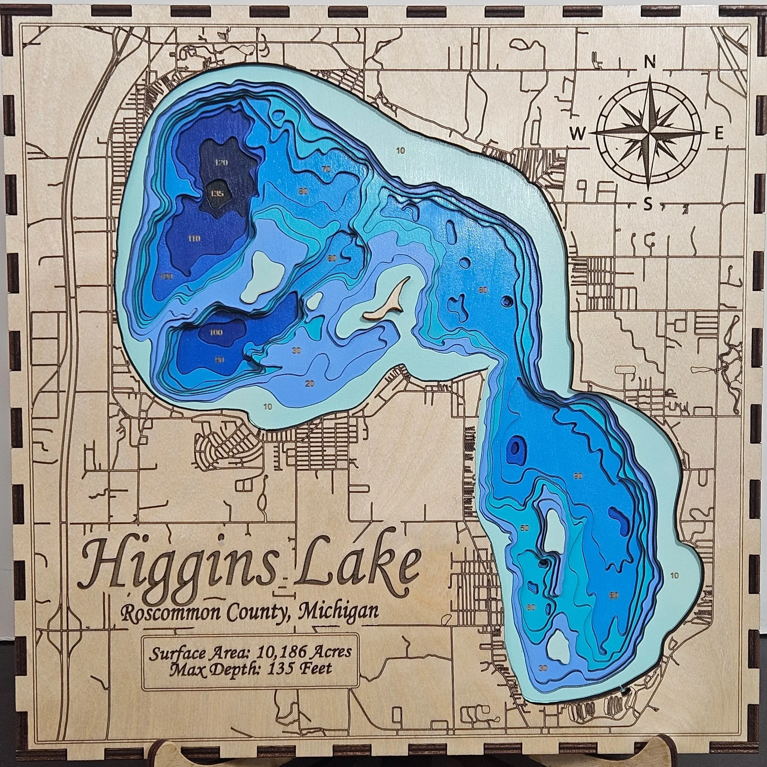 Map of Higgins Lake in Roscommon County, Michigan, with contour lines indicating water depths in shades of blue, and surrounding roads and land features. Title and details about the lake's surface area and maximum depth are at the bottom.