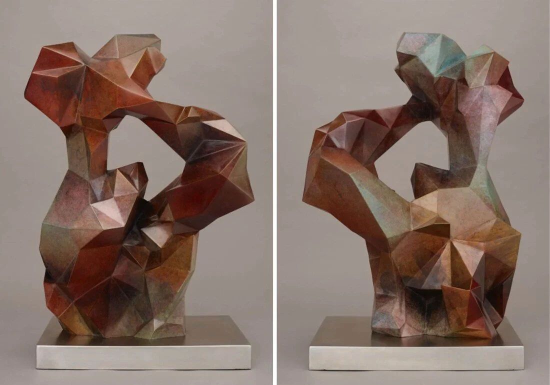 Geometric abstract sculpture of a dog, made of multicolored faceted metal pieces, mounted on a silver base.