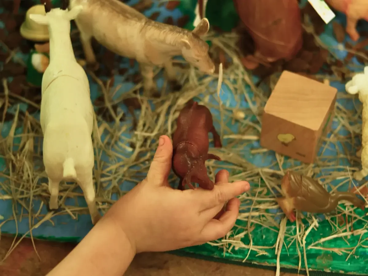 Child playing with farm animal figurines