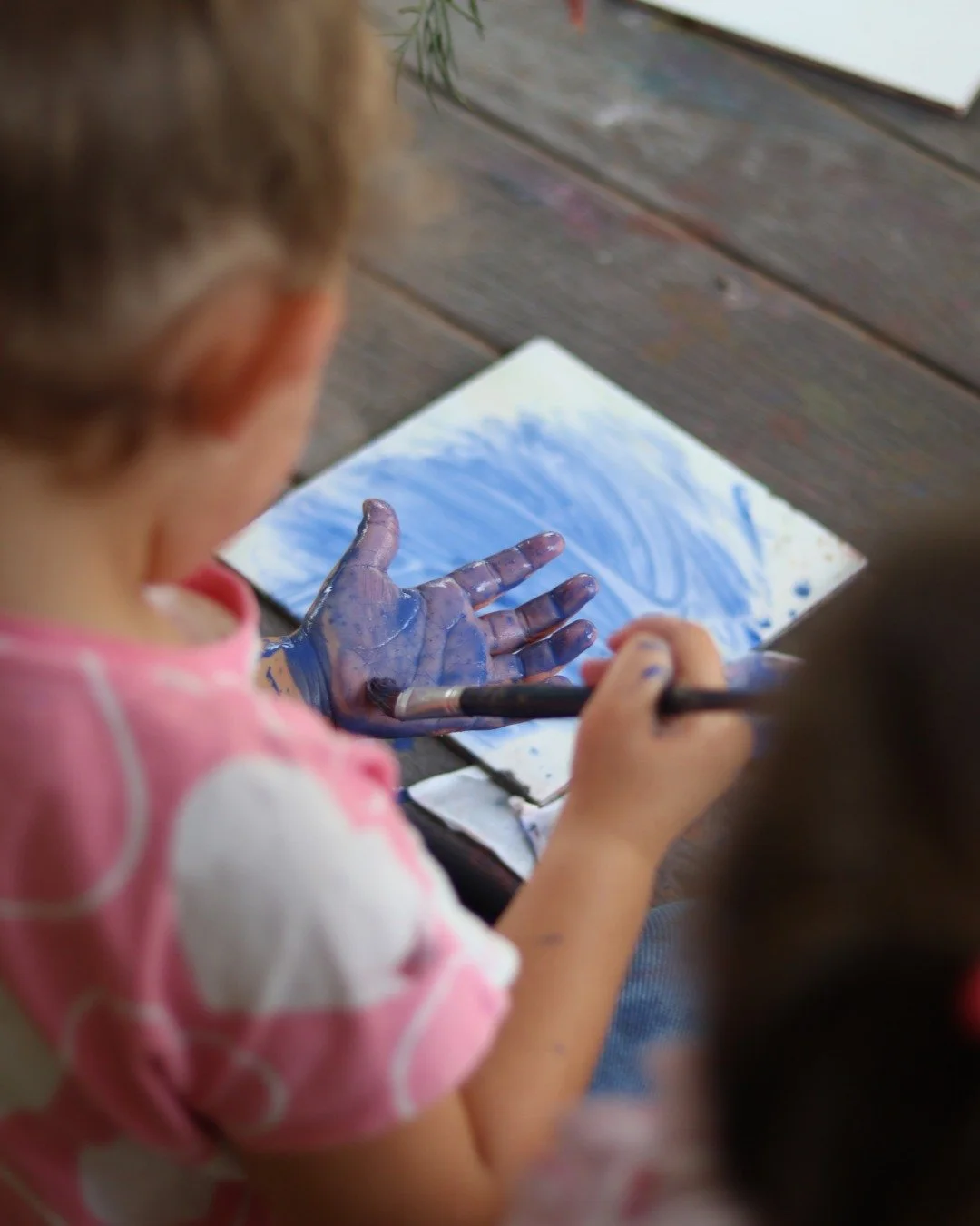 Have you ever wondered why your child puts more paint on themselves than the paper? 

It's all part of their full-body, sensory exploration of the world and making meaning of their experiences. They are using the Enveloping Schema in their play to le