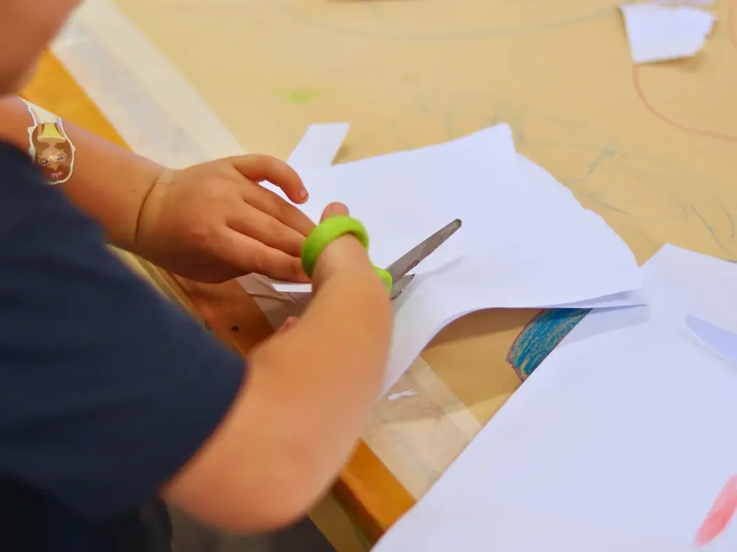 Child cutting paper with scissors