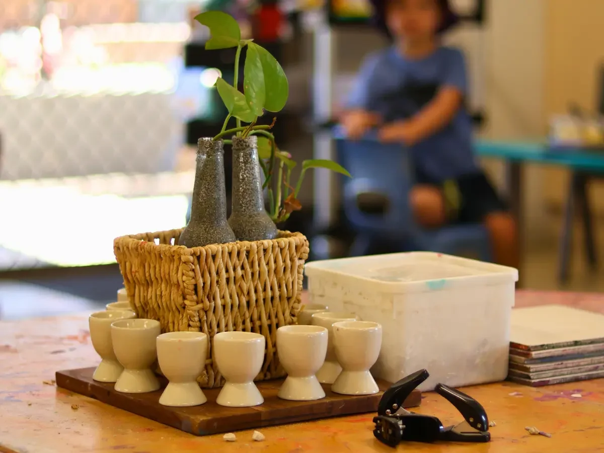 Aesthetic crafting table display with a collection of egg cups and a decorative plant