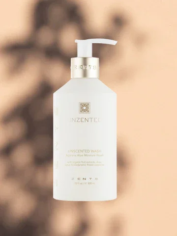 White bottle of unscented moisturizer with pump dispenser on a blurred background.