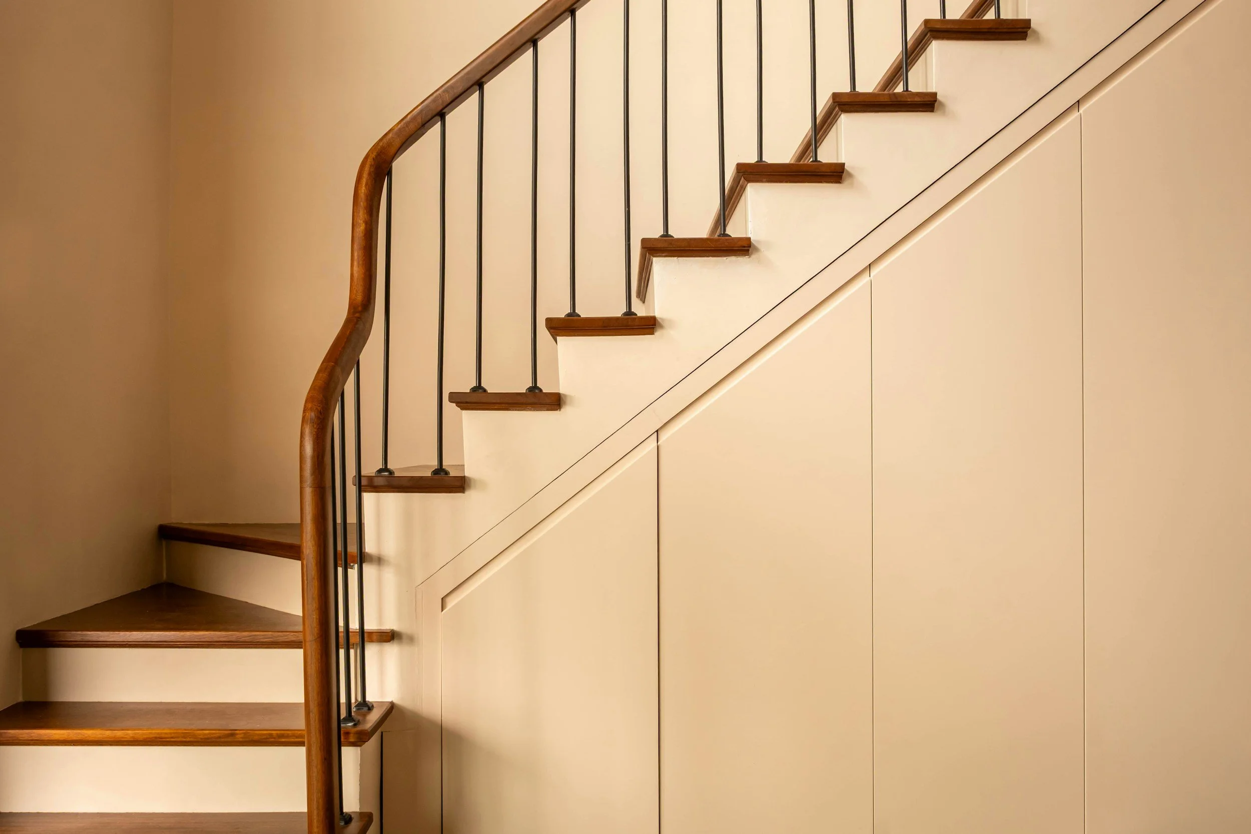 staircase with wood handrail empty walls