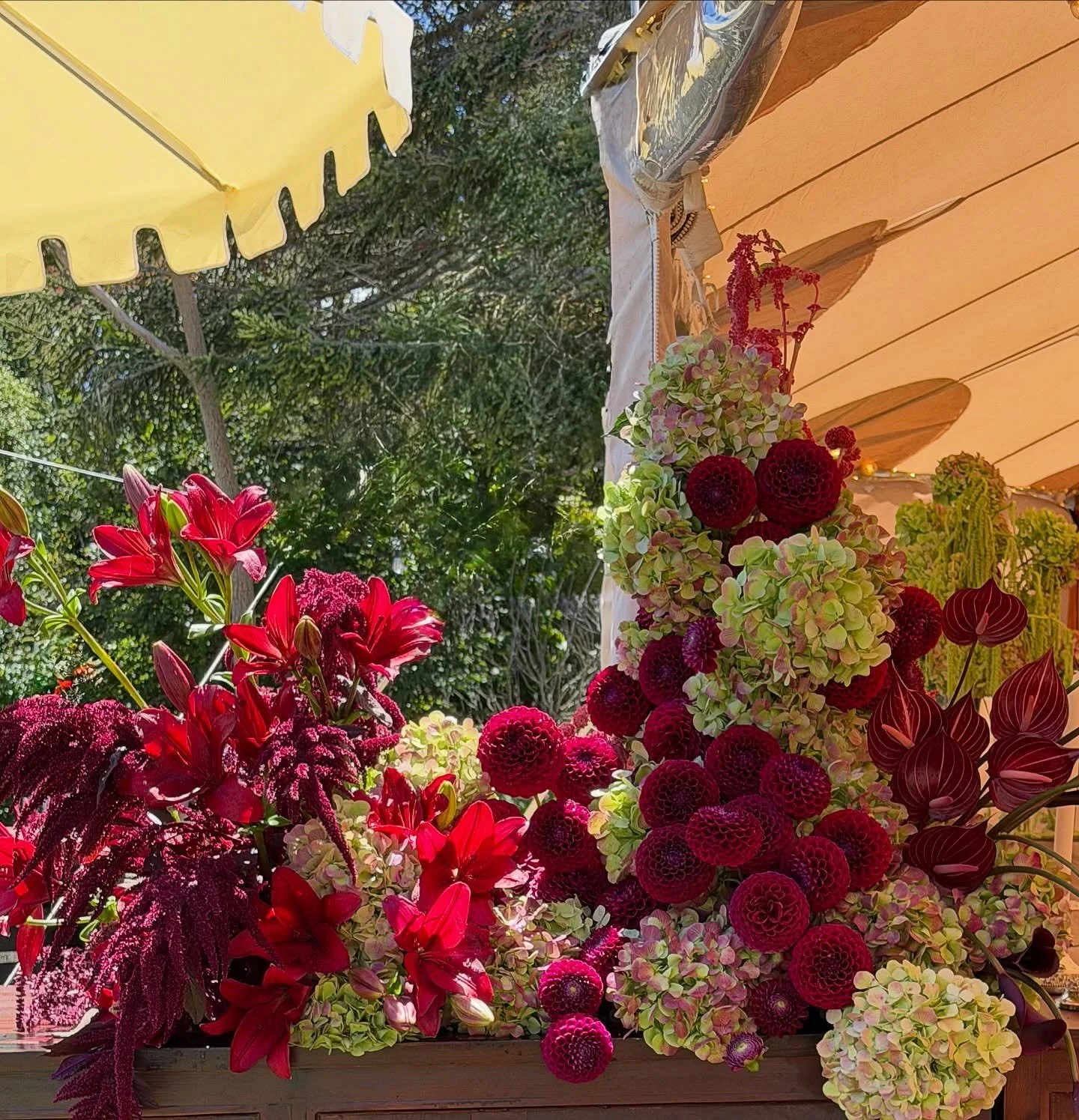 A couple of bar moments designed to be seen from every angle.

Layering deep crimson Dahlias, Anthuriums, Lilies and trailing Amaranthus with soft Hydrangea to create a sculptural floral installation right where guests naturally gather throughout the