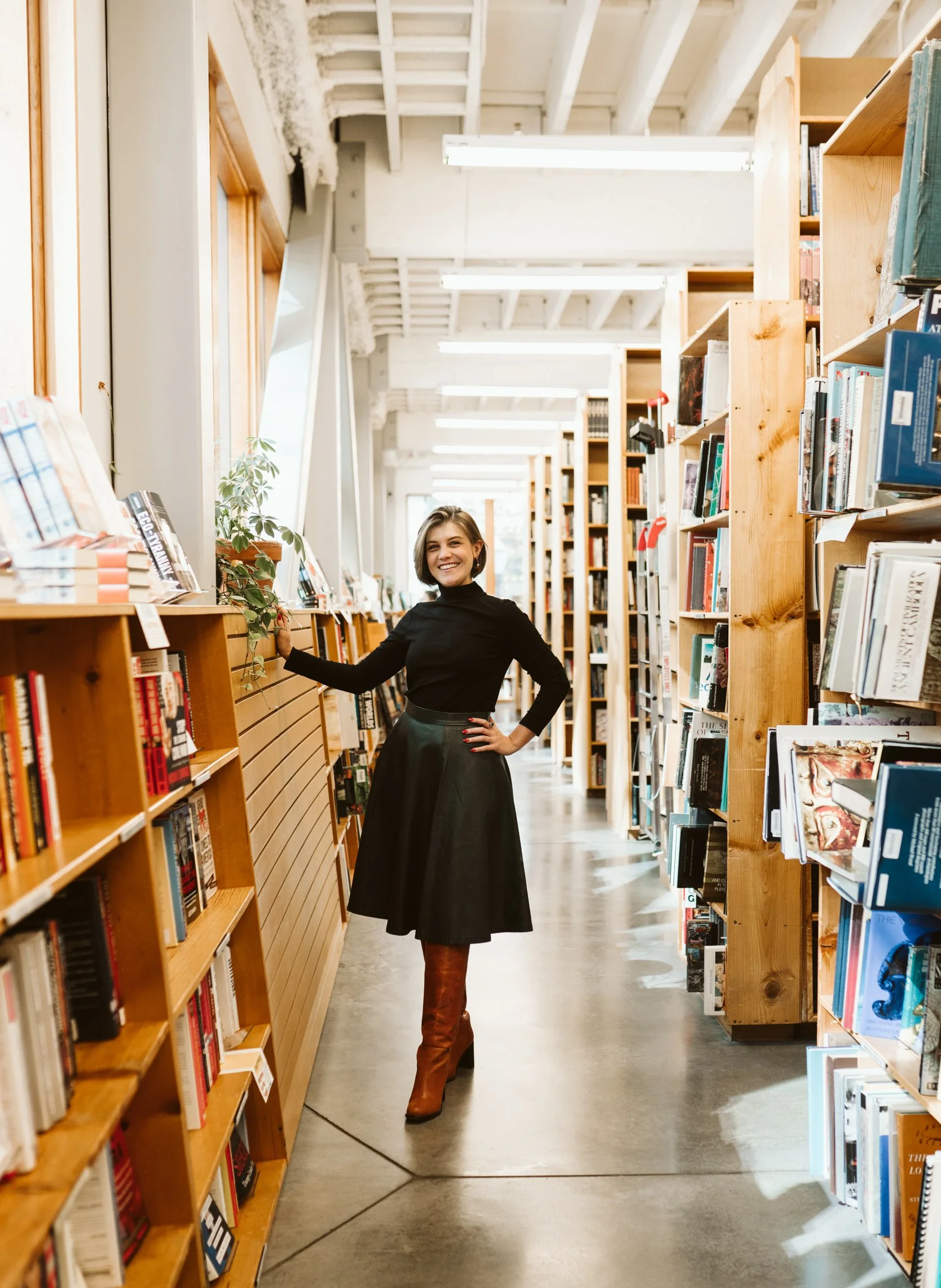Meg Pompetti stands smiling in a bright library