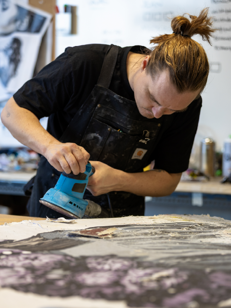René Konings sanding one of his handmade canvases