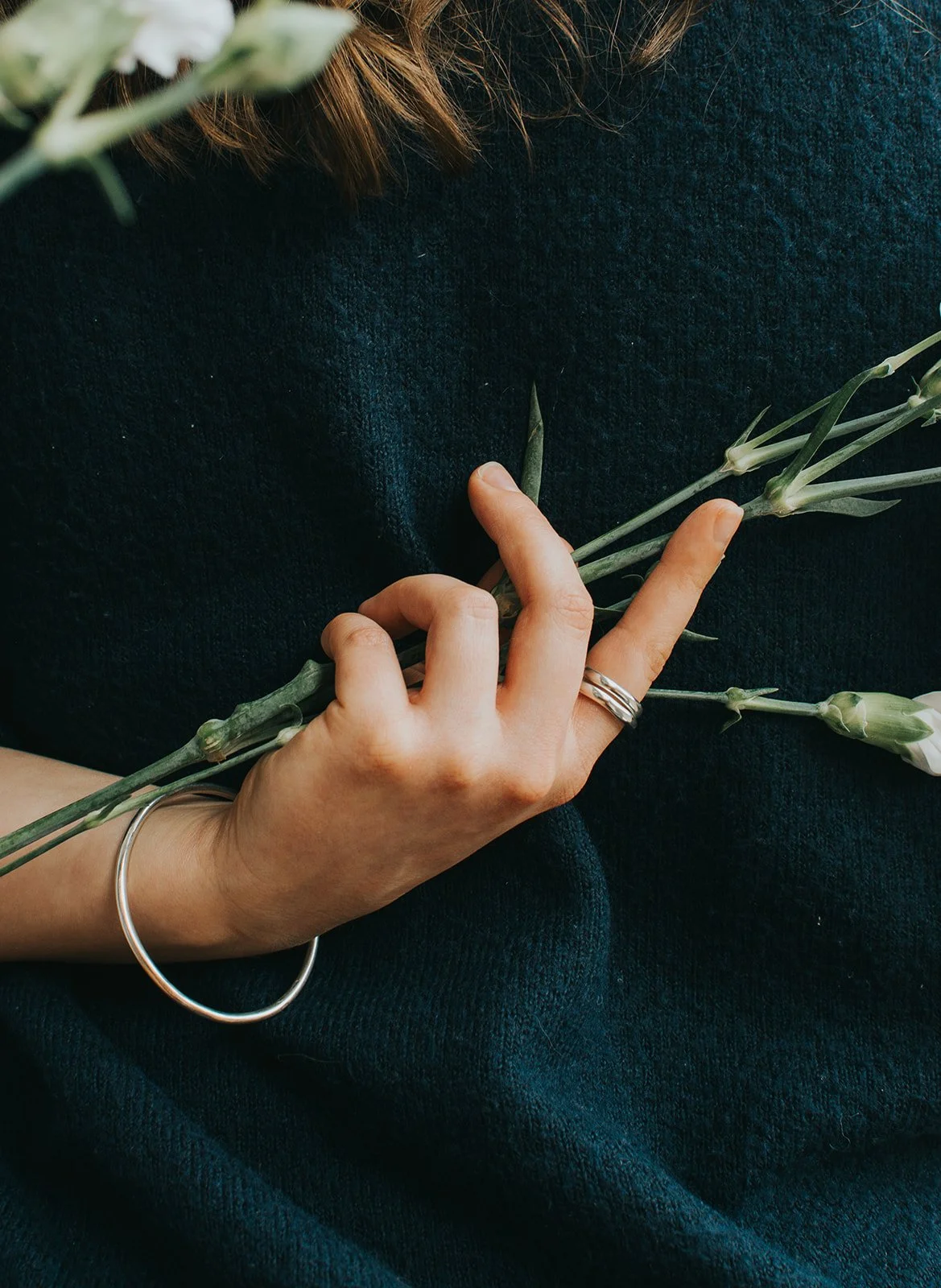 Two silver rings placed on a white surface.