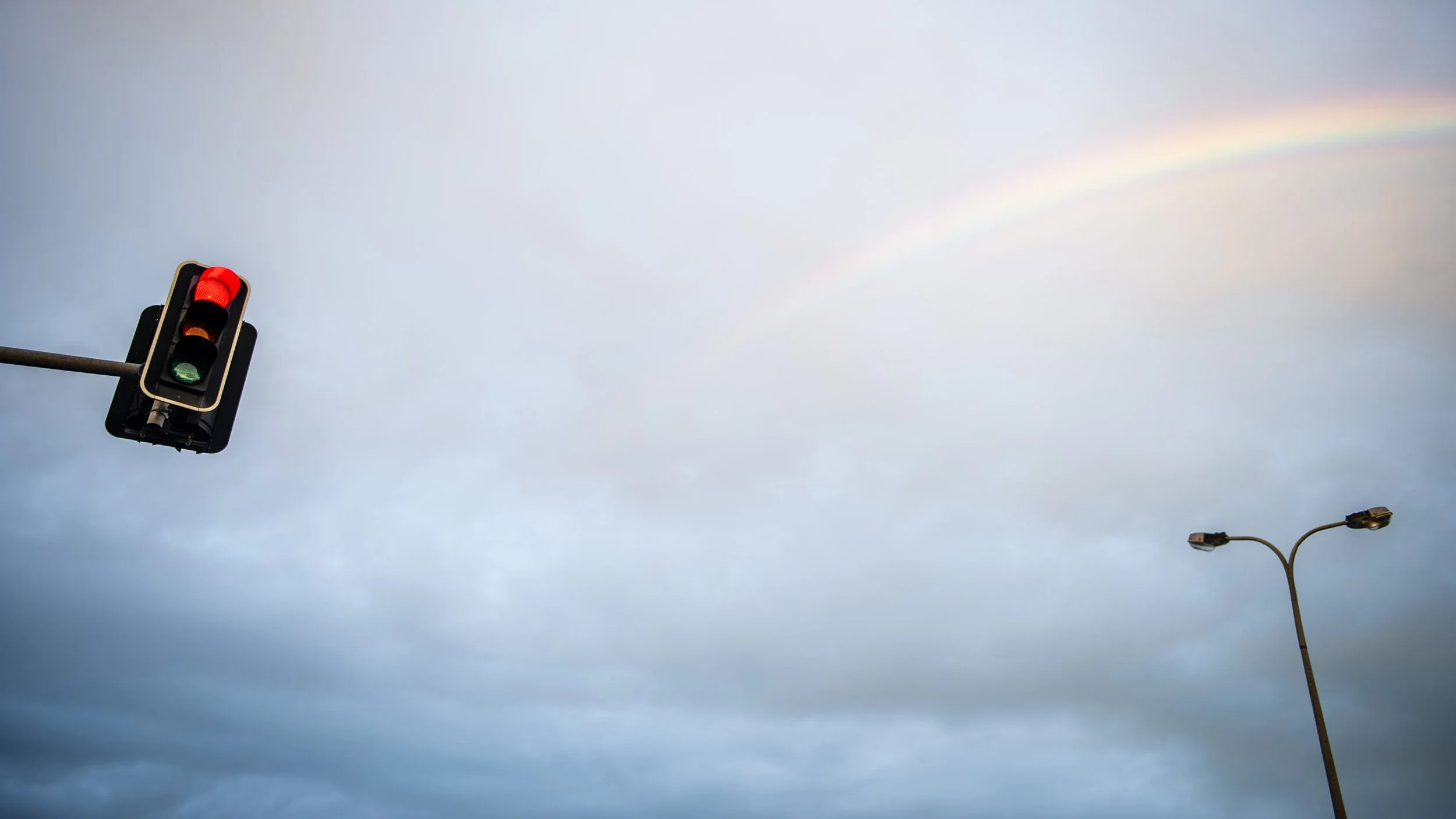 "Pause"
Winter asks us to pause. The red light arrests our progress while the rainbow offers a promise beyond the clouds. In between lies a moment of reflection, where uncertainty gives way to possibility. The work suggests that hope is not found by 