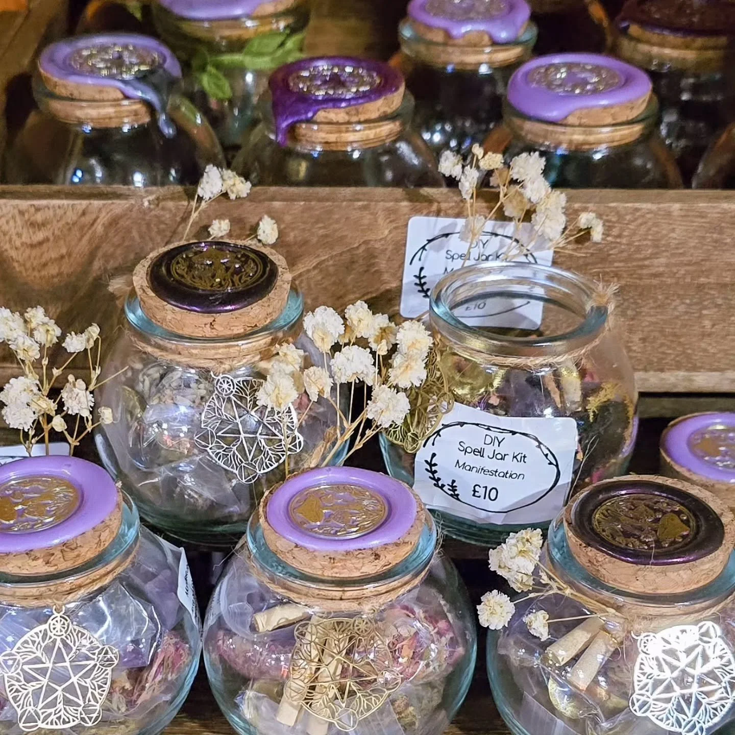 Our DIY Spell Jars!
How to use:
- Take out the contents of the jar
- Pour the herb mixture in, then add the moss and sprinkle the crystals on top. Top the contents off with gold bark and crystals.
- Write on the scrolls your intentions for the spell