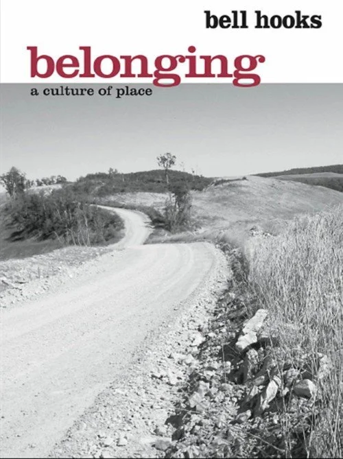 Black and white cover of a book titled 'Belonging: A Culture of Place' by Bell Hooks, featuring a winding dirt road through a rural landscape with hills and trees.