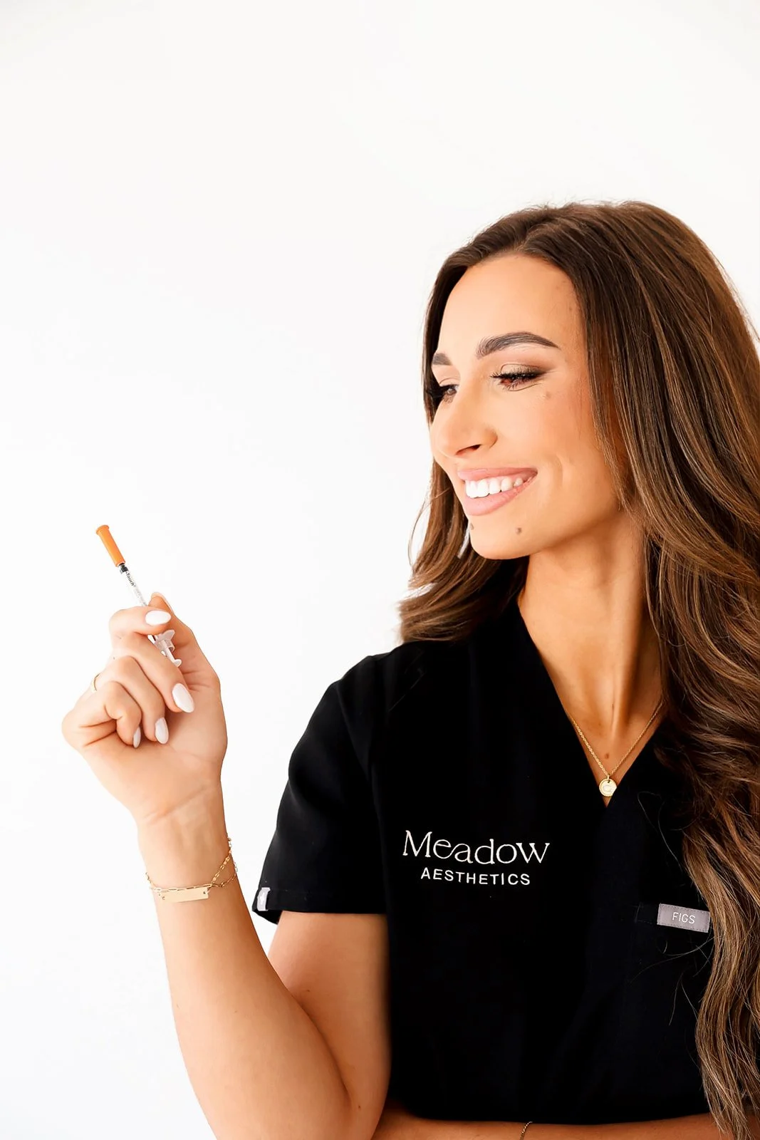 Addison, nurse injector, holding syringes to promote weight loss services at Meadow Med Spa + Aesthetics in Wichita, KS.