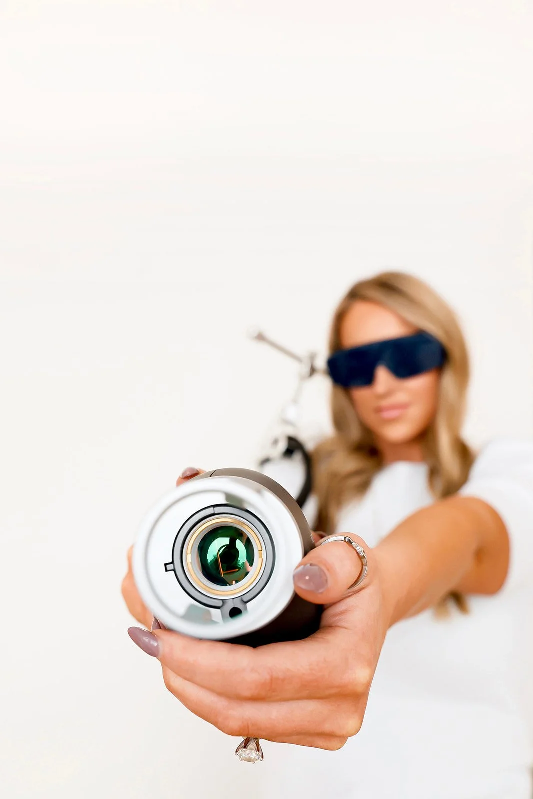 Mackenzie, nurse injector and owner, holding nouvaderm laser to promote laser resurfacing services at Meadow Med Spa + Aesthetics in Wichita, KS.