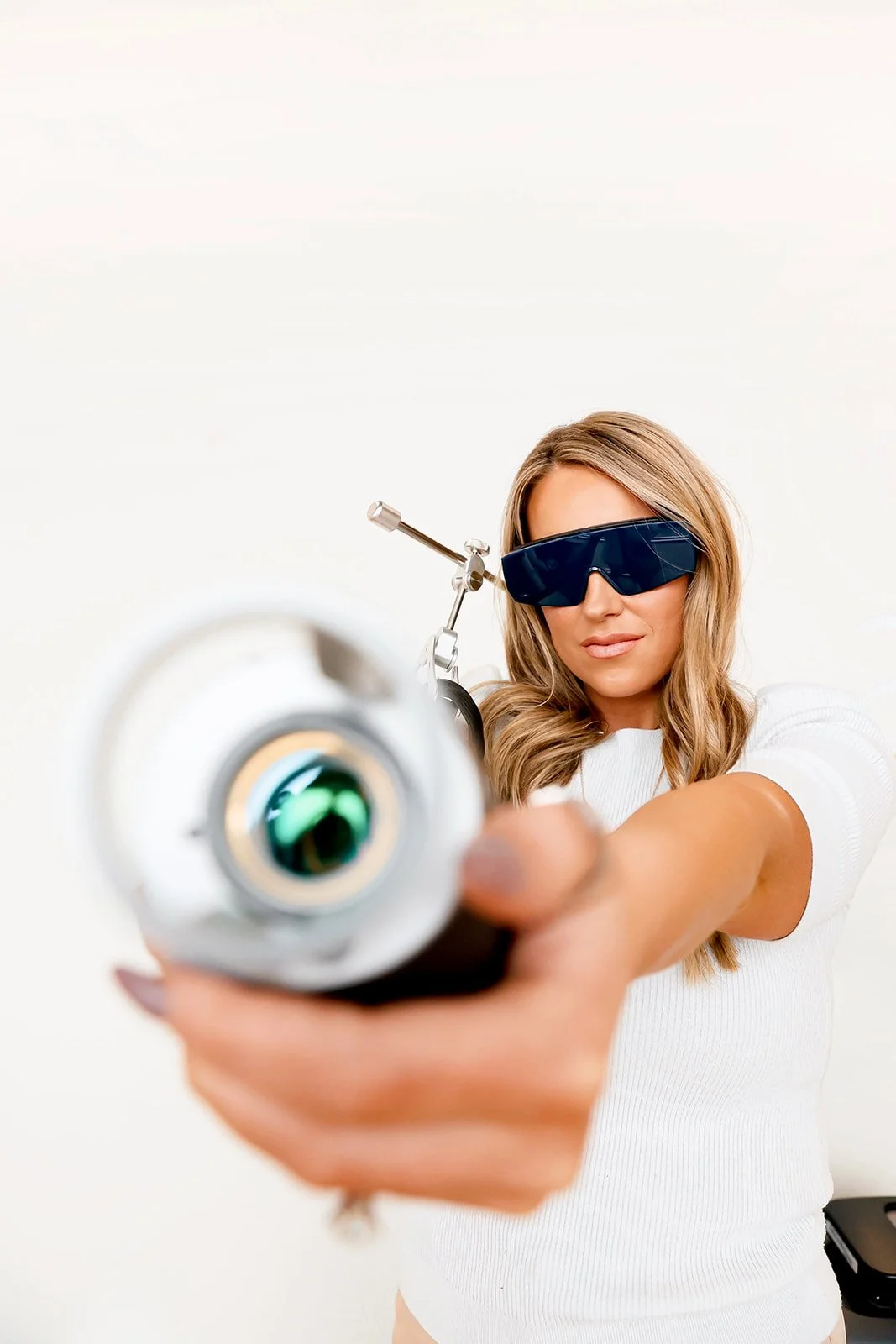 Mackenzie, owner & nurse injector at Meadow Aesthetics in Wichita, KS, holding NouvaDerm laser to promote laser treatments.