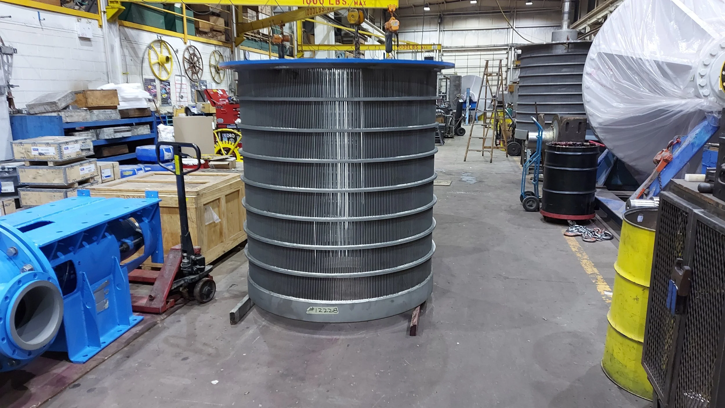 Sunrise Engineering - A large industrial cooling tower or heat exchanger with horizontal cooling fins situated in a factory or workshop setting.