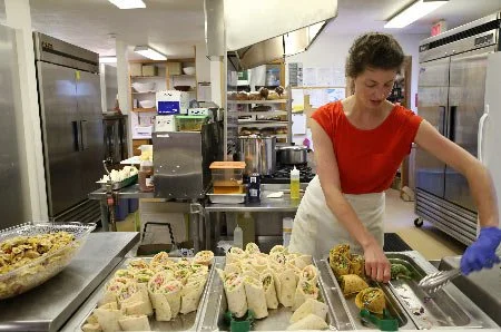 Woman preparing sandwiches in a professional kitchen