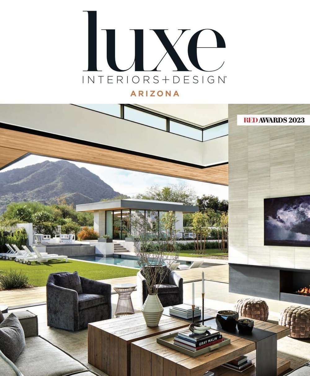 Snippet from “Luxe Interiors + Design” magazine featuring an open concept living space with large sliding patio doors opening to a spacious patio with pool and casita. 