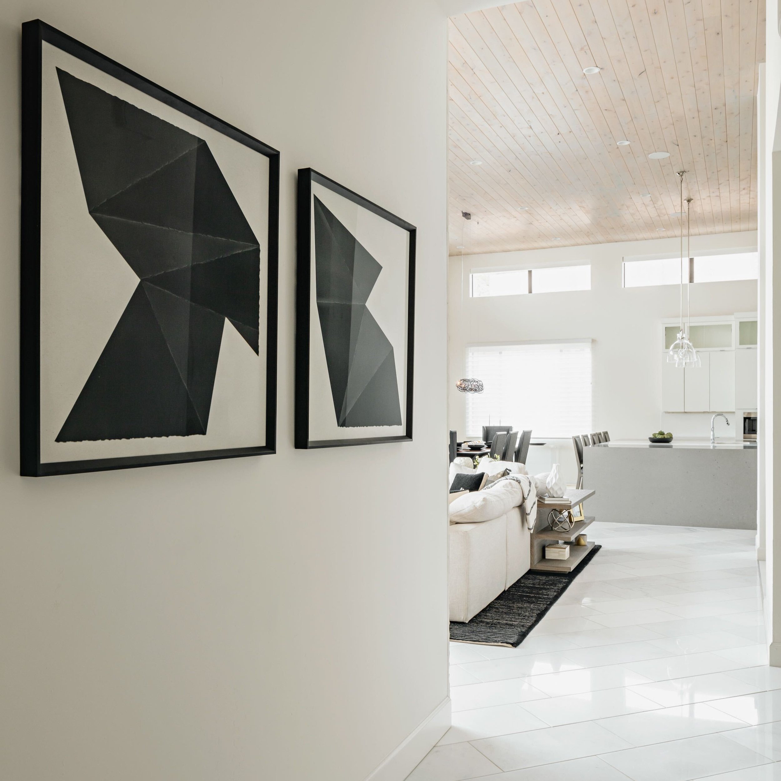  Framed black and white wall art in a luxurious, monochromatic home remodel.  