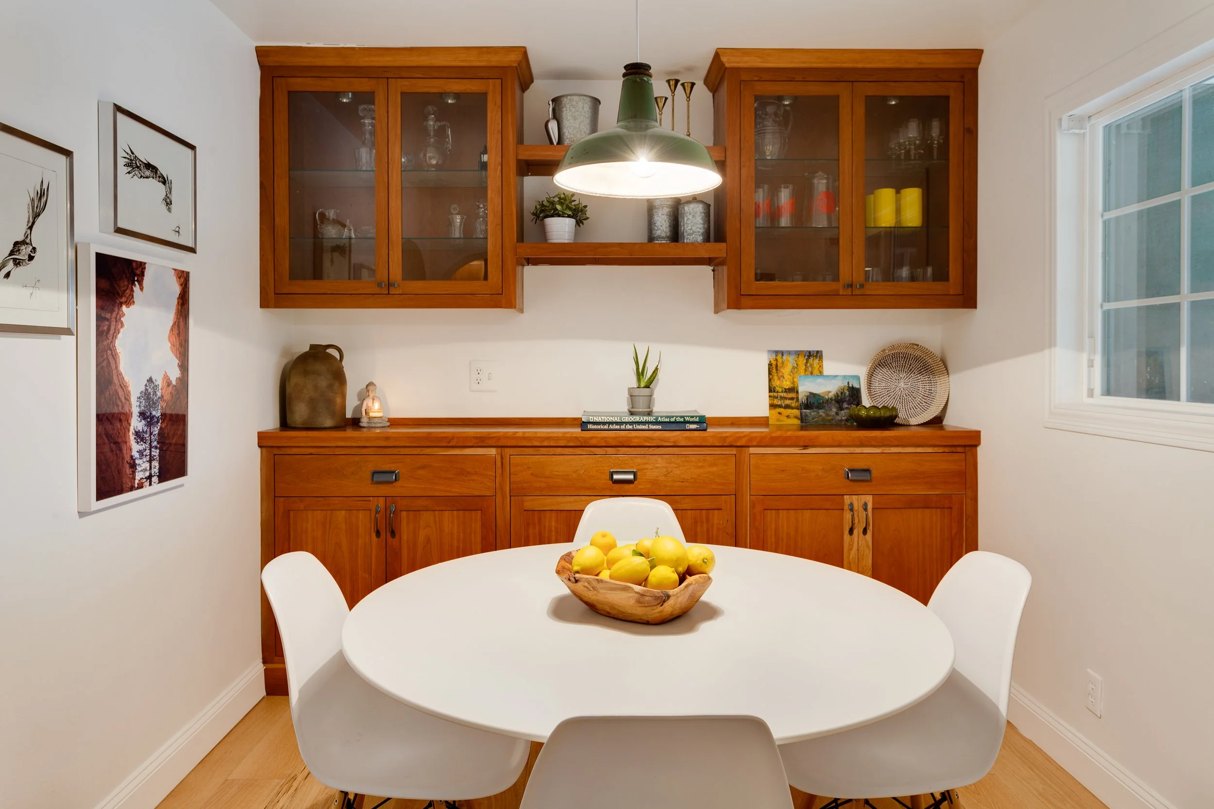 a bowl of lemons on a round white table in a kitchen.