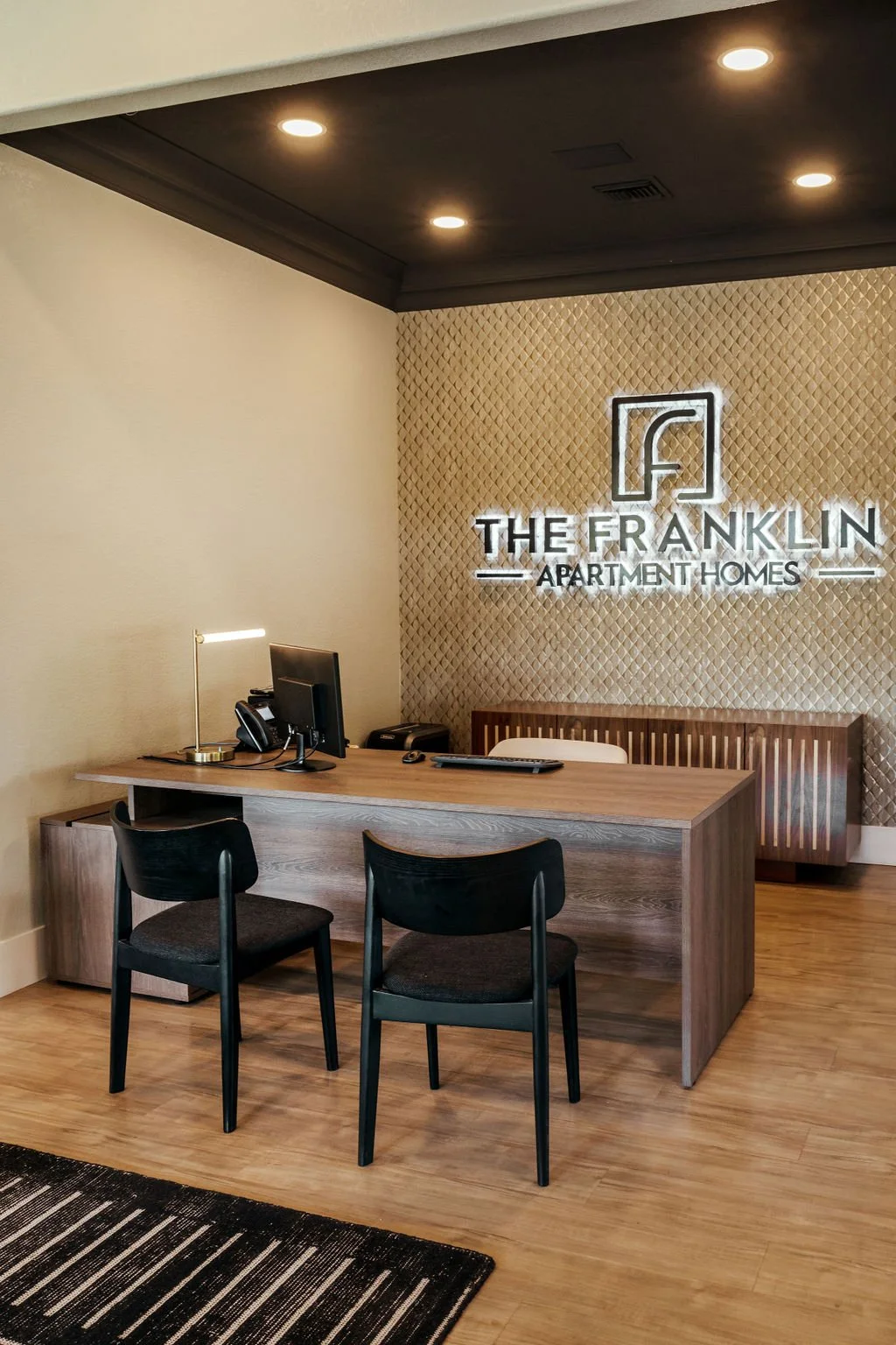 The Franklin Peoria AZ multifamily apartment - front desk with metallic 3D wallpaper and custom signage
