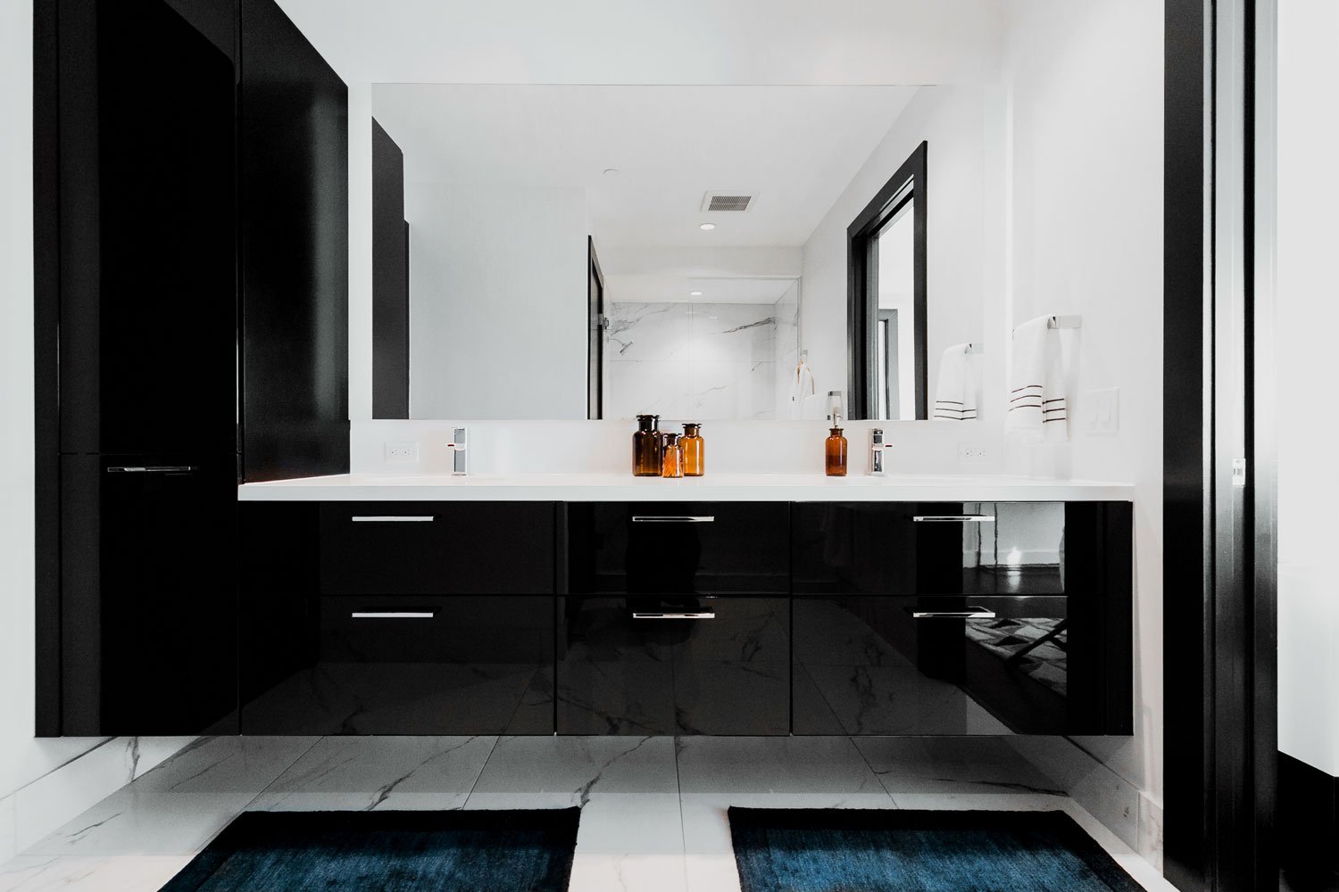 Elevated double vanity and extra tall linen closet provide ample counter space and extra storage in this modern and masculine bathroom.