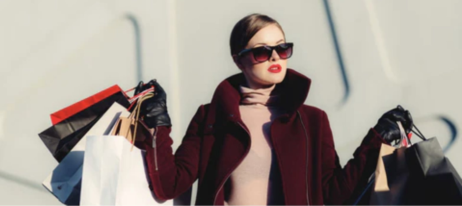 A woman holding shopping bags in a red coat