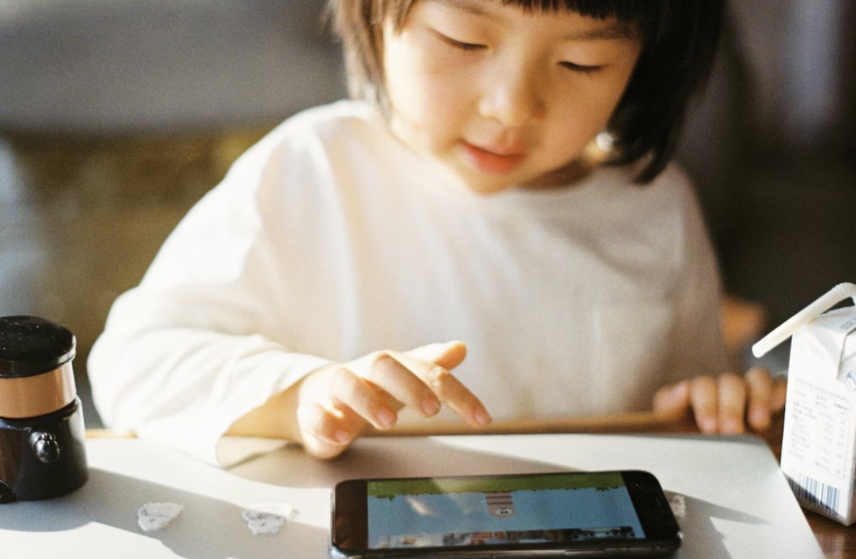 A photo of a child playing on a tablet