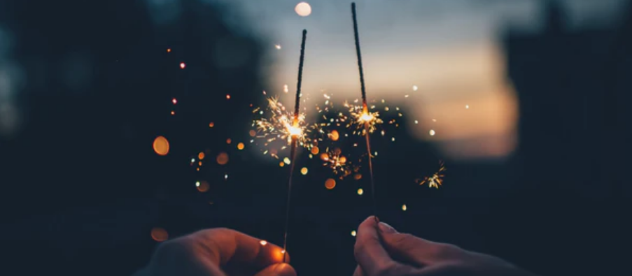a pair of hands holding sparklers