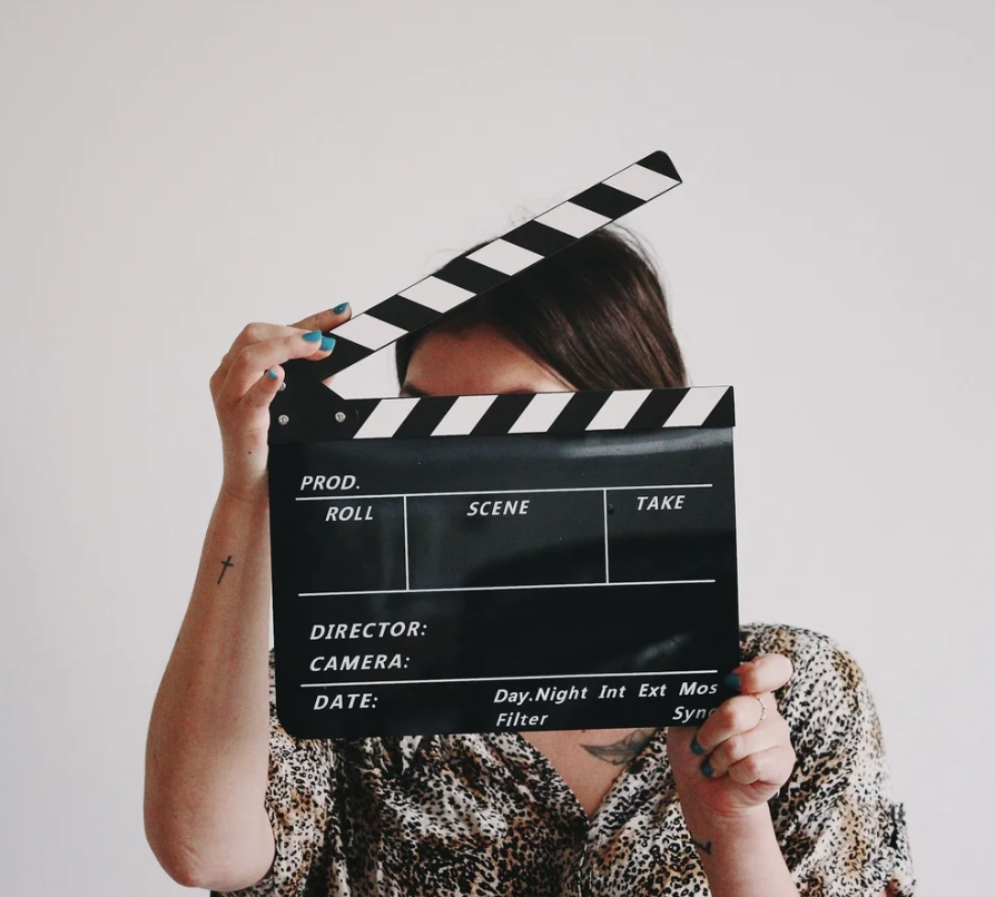 A person holding a film slate in front of their face.