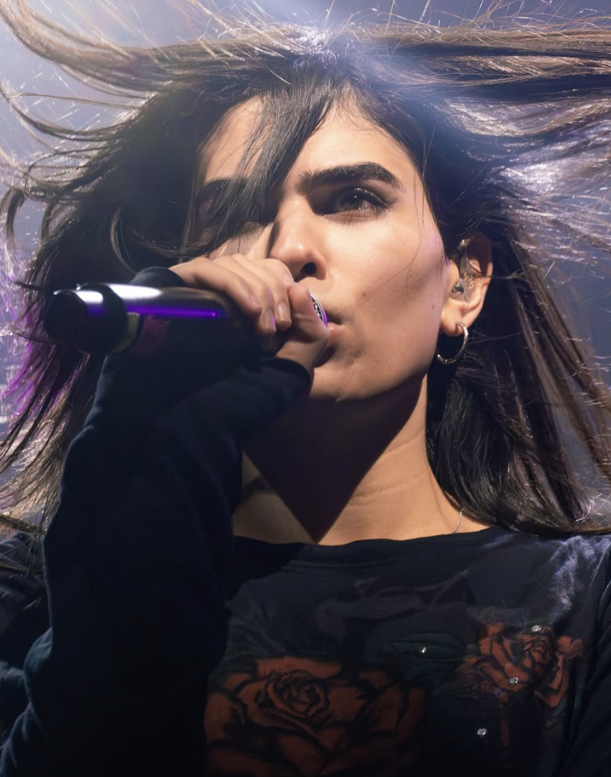 A photo of Underscores singing, hair in her face