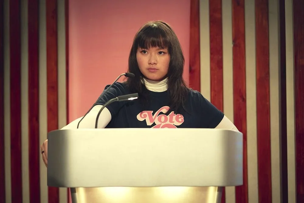 A person stands at a podium looking concentrated.