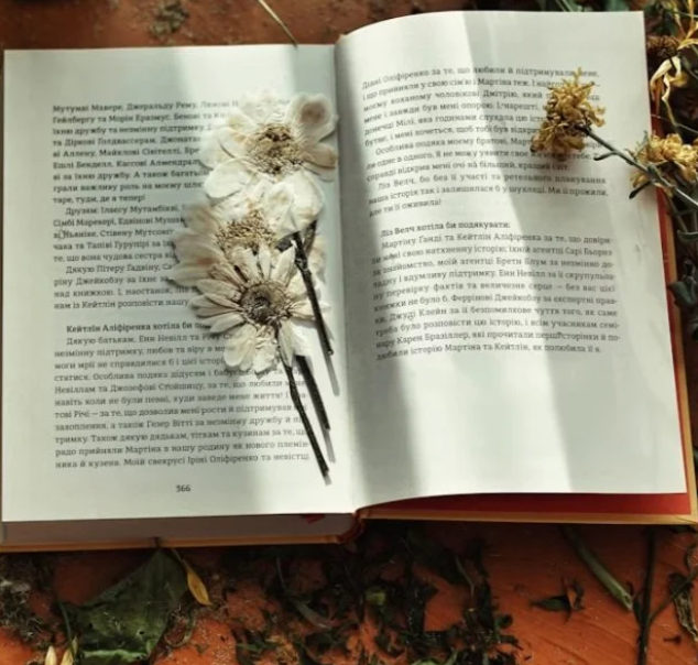 An open book with flowers on top.
