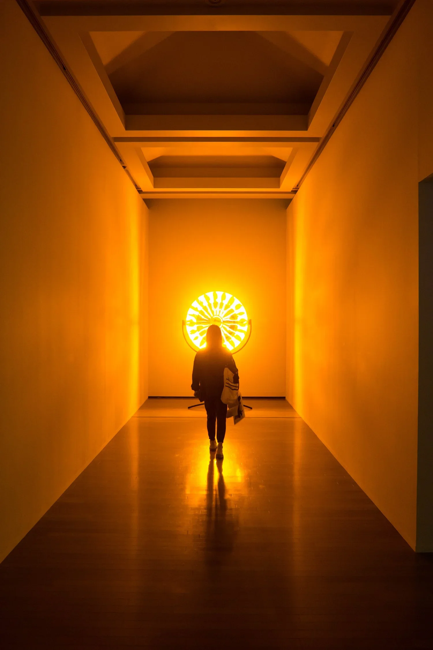 A person walking towards a textured orange globe