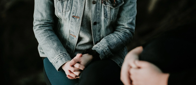 someone sitting down putting their hands in their lap