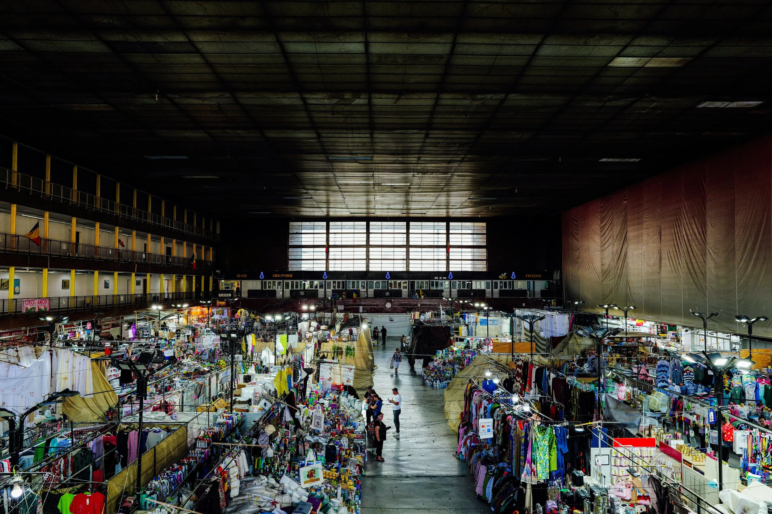 A photo of the interior of a warehouse filled with consumer goods and vendor stalls.