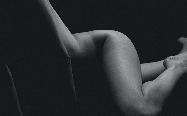 a black and white photo of a naked body posed sensually