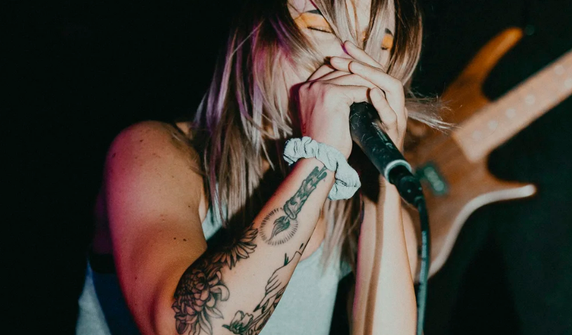 An image of a woman singing into a mic
