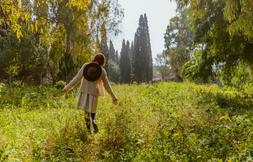 a person running through a field surrounded by trees