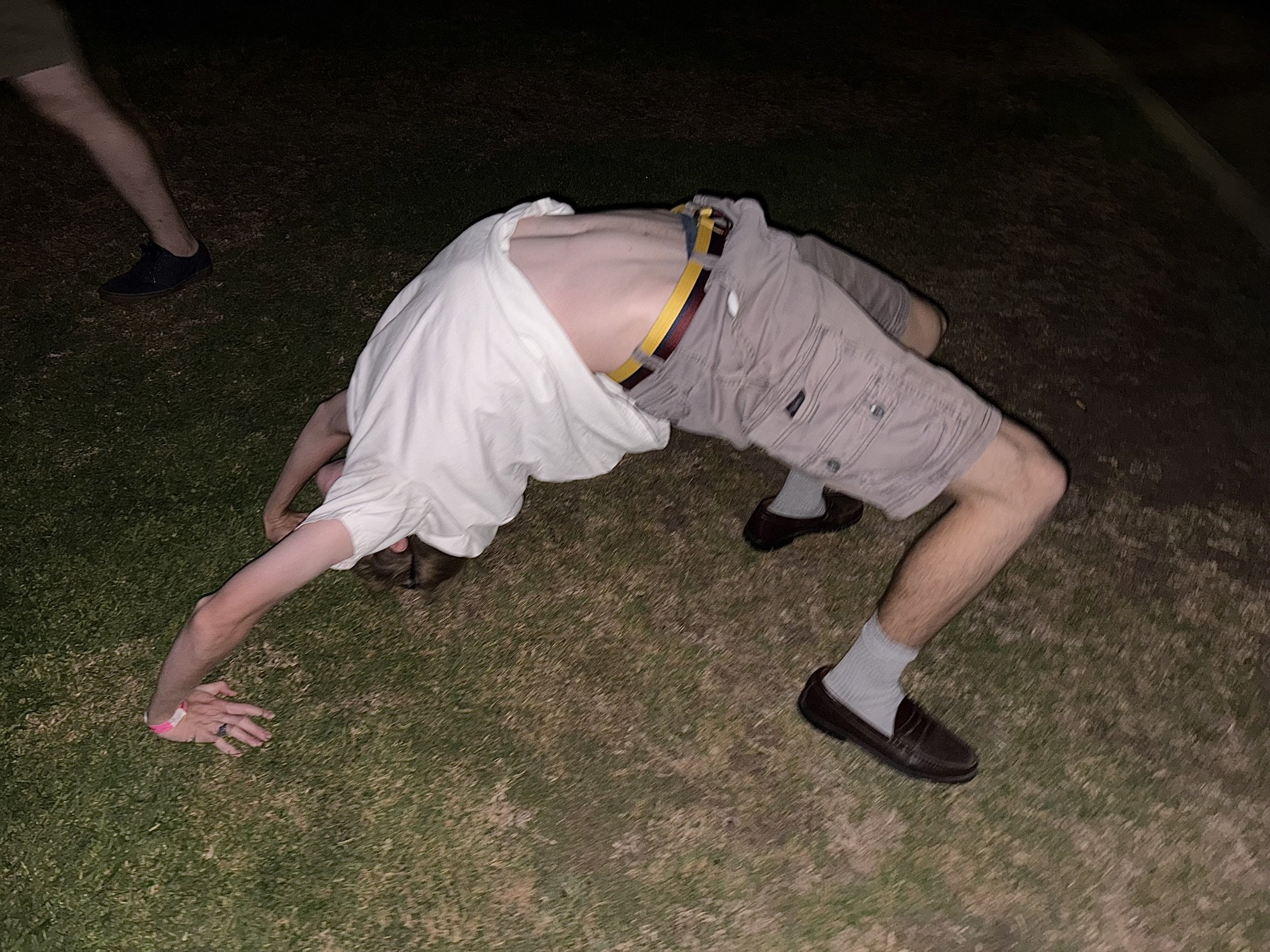 A person doing a backbend on grass